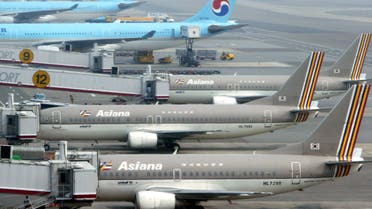 Planes from Asiana Airlines (foreground) and Korean Airlines are parked on the tarmac of Kimpo airport in Seoul, July 21, 2005. (Reuters)