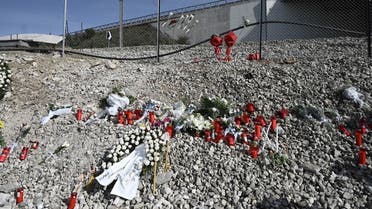 A photo shows flowers and candles layed during a commemorative prayer on March 9, 2023, at the site of a train accident which killed 57 on February 28, in Greece's worst rail disaster, near the central city of Larissa. At least 57 people were killed, and 14 others remain in hospital after a freight train crashed head-on with a passenger train, carrying mostly students, on February 28, 2023. (Photo by Sakis MITROLIDIS / AFP)