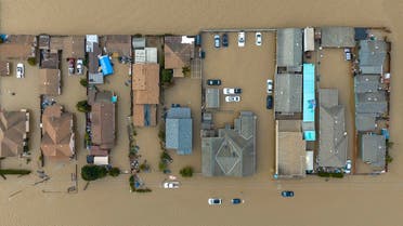 This aerial photograph shows vehicles and homes in floodwaters in Pajaro, California on Saturday, March 11, 2023. Residents were forced to evacuate in the middle of the night after an atmospheric river surge broke the the Pajaro Levee and sent flood waters flowing into the community. (Photo by JOSH EDELSON / AFP)