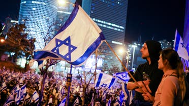 People hold Israeli flags during a demonstration as Israeli Prime Minister Benjamin Netanyahu's nationalist coalition government presses on with its contentious judicial overhaul, in Tel Aviv, Israel, March 11, 2023. (Reuters)