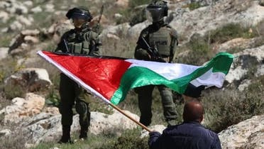 فلسطینی اسرائیلی فوج کے سامنے جھنڈا لہرا رہا ہے