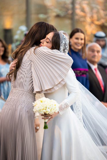 A handout picture released by Jordanian Royal Palace shows Queen Rania of Jordan congratulating her eldest daughter Princess Iman during her wedding ceremony with Jameel Alexander Thermiotis (not in the picture) in Amman on March 12, 2023. (AFP)