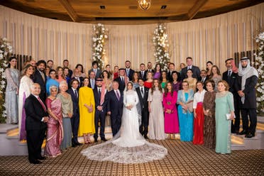 A handout picture released by Jordan's Royal Palace shows King Abdullah II (7th L) and Queen Rania (6th R) posing for a picture with members of the Jordanian royal family and the bride and groom. (AFP)