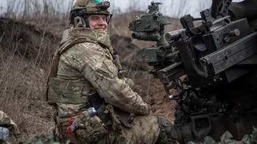 A Ukrainian service member from a battalion, named of nom-de-guerre of their commander 'Da Vinci', Hero of Ukraine, who was killed in a fight against Russian troops, smiles as he fires a howitzer M119 at a front line, amid Russia's attack on Ukraine, near the city of Bakhmut, Ukraine March 10, 2023. REUTERS/Oleksandr Ratushniak