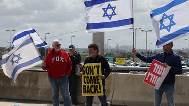 Anti-government protesters wave national flags as they demonstrate outside Ben Gurion airport near Tel Aviv against the controversial judicial reform bill as Prime Minister Benjamin Netanyahu heads to Germany on an official visit on March 15, 2023. (AFP)