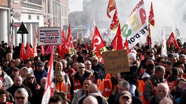 Protesters hold flags and placards during a demonstration on a 8th day of strikes and protests across the country against the government's proposed pensions overhaul in Calais, on March 15, 2023. France faces another day of strikes over highly contested pension reforms which President appears on the verge of pushing through despite months of protests. As the legislation enters the final stretch in parliament, trade unions are set to make another attempt to pressure the government and lawmakers into rejecting the proposed hike in the retirement age to 64. (Photo by Sameer Al-Doumy / AFP)