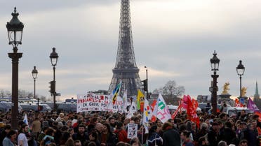 Demonstrators holds banners as they gather on the place de la Concorde near the National Assembly, with the Eiffel tower in the background, to protest after French Prime Minister Elisabeth Borne delivered a speech to announce the use of the article 49.3, a special clause in the French Constitution, to push the pensions reform bill through the lower house of parliament without a vote by lawmakers, in Paris, France, March 16, 2023. (Reuters)