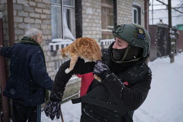 متطوع اوكراني يحمل قطة خلال مساعدته في إجلاء السكان من مناطق القتال في دونيتسك