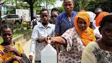 People come to wash their hands with chlorinated water at Muhimbili National Hospital in Dar es Salaam, Tanzania, a few hours after the government announces the first case of the COVID-19 in the country on March 16, 2020. (AFP)