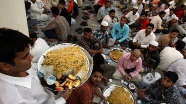 An Asian man brings food to scores of foreign Muslim workers waiting to break ther fast at a charity tent in Dubai on September 16, 2008. (File photo: AFP)