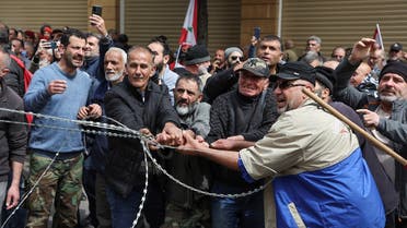 Retired Lebanese soldiers pull a barbed wire during a protest over the deteriorating economic situation, at Riad al-Solh square in Beirut, Lebanon, on March 22, 2023. (Reuters)