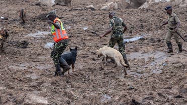 Malawi Police Service Dog Handlers lead sniffer dogs into the area of mudslide disaster during a joint search and rescue operation to recover bodies of victims of the mudslide at Manje informal settlement up on the slopes of Soche Hill in Blantyre, Malawi, on March 17, 2023. (AFP)
