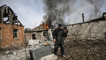 A man stands outside a burning house after shelling in the town of Chasiv Yar, near Bakhmut, on March 21, 2023, amid the Russian invasion of Ukraine. (AFP)