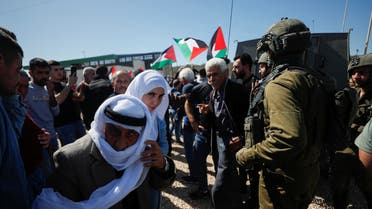 Palestinians take part in a protest against a new Israeli settlement as Israeli forces stand guard near their vehicle near Ramallah in the Israeli-occupied West Bank, March 10, 2023. REUTERS/Mohamad Torokman