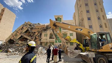 Qatari security forces and rescuers gather in front of a building that collapsed in Doha, reportedly killing one person and injuring others, on March 22, 2023. (AFP)