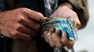A vendor counts his earnings of the day in front of a branch of the Kabulbank in Kabul September 14, 2010. Afghanistan's central bank has stepped in to take control of the troubled Kabulbank, its governor said on Tuesday, after suspected irregularities raised concerns over the country's top private financial institution. (Reuters)