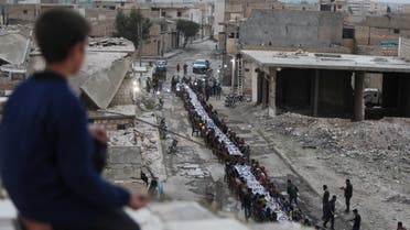 Syrians gather in a heavily damaged area to break their fast during an iftar gathering organised by an NGO in coordination with various local factions in Tadef, near the border city of al-Bab, which is controlled by Turkish-backed rebels in Syria's eastern countryside of Aleppo province on April 18, 2022. (File photo: AFP)