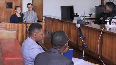 American couple, Nicholas Spencer (2L) and his wife, Mackenzie Leigh (L), both 32, stand in the dock at Buganda road court charged with torturing ten-year-old John Kayima under their foster care in addittion to aggravated child trafficking, in Kampala, February 2, 2023. (AFP)