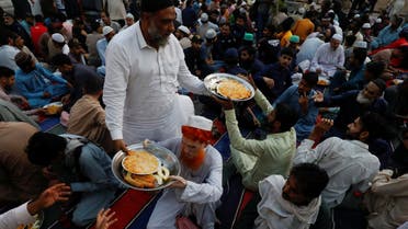 A man distributes food plates before Iftar (breaking fast) during the fasting month of Ramadan, at a mosque in Karachi, Pakistan March 23, 2023. (Reuters)