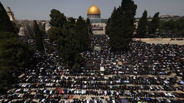 People perform the first Friday noon prayer of the Islamic fasting month of Ramadan, in front of the Dome of the Rock shrine at the Al-Aqsa mosque compound in Jerusalem, on March 24, 2023. (AFP)