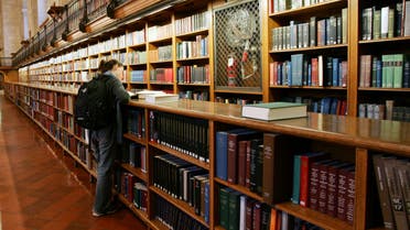A woman stands among the bookshelves in the main reading room of The New York Public Library, December 14, 2004. (File photo: Reuters)