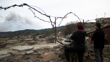 People observe smoke from a wildfire in San Agustin, Spain, March 24, 2023. (Reuters)