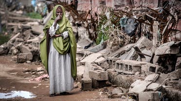 A woman reacts while looking at the destruction left after heavy rains and floods in the school in front of her house in Beledweyne, Somalia, on December 14, 2019. (AFP)