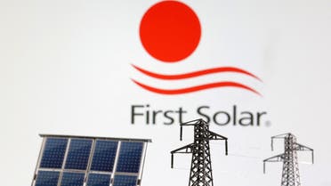Miniatures of solar panel and electric pole are seen in front of First Solar logo in this illustration. (Reuters)