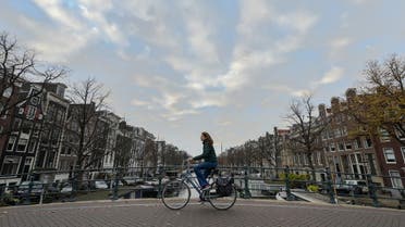 A woman rides a bike in Amsterdam, western Netherlands, on November 24, 2021. (AFP)