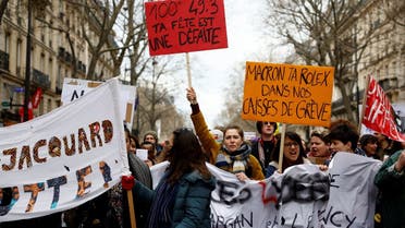 Students hold placards during a demonstration, as part of the tenth day of nationwide strikes and protests against French government’s pension reform in Paris, France, on March 28, 2023. The slogan reads “Macron, your Rolex in our strike funds.” (Reuters)