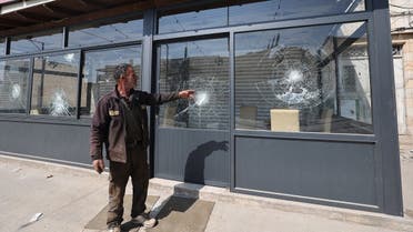 A man points to the damaged glass of a restaurant following a reported attack by Israeli settlers on the Palestinian town of Huwara in the occupied West Bank on March 28, 2023. (AFP)