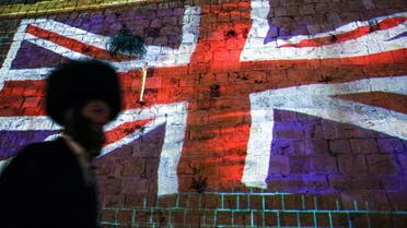 An ultra-Orthodox Jewish man walks past a projection of the British Union Jack flag displayed on the walls of the old city of Jerusalem on September 10, 2022, days following the death of Queen Elizabeth II of the United Kingdom. (AFP)