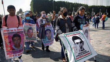 FILE PHOTO: Relatives of missing students hold posters with their images as they arrive for a mass to mark the disappearance of the 43 Ayotzinapa College Raul Isidro Burgos students in the state of Guerrero, at the Basilica of Our Lady of Guadalupe in Mexico City, Mexico December 26, 2022. (Reuters)