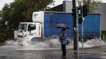 A pedestrian stands on the corner of a flooded street as heavy rains affect Sydney, Austral-ia. (File photo: Reuters)