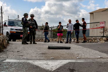 Israeli police bomb disposal unit members and other stand by the remains of a shell fired from Lebanon and intercepted by Israel in its northern town of Fassuta on April 6, 2023. (AFP) 