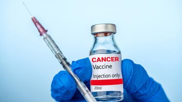 Doctor or nurse is holding the Cancer vaccine and syringe with her blue glove. stock photo