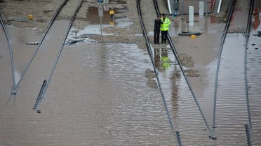 Railway workers stand at a flooded train station in Tel Aviv January 8, 2013. (Reuters)