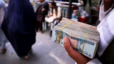 A person holds a bundle of Afghan afghani banknotes at a money exchange market, following banks and markets reopening after the Taliban took over in Kabul, Afghanistan, September 4, 2021. (Reuters)