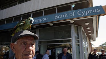 A man with a parrot on his head is seen outside a Bank of Cyprus branch in the Cypriot capital, Nicosia, on March 28, 2013. (AFP)