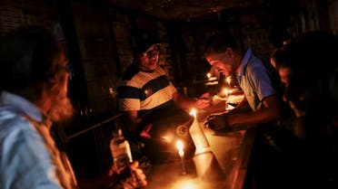 A pharmaceutical shop uses candle lights to serve customers during countrywide blackout in Dhaka, Bangladesh, October 4, 2022. (File photo: Reuters)