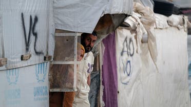 Syrian refugees look out from a tent at an informal settlement, during the holy month of Ramadan, in Al-Marj, Bekaa, Lebanon April 5, 2023. (Reuters)