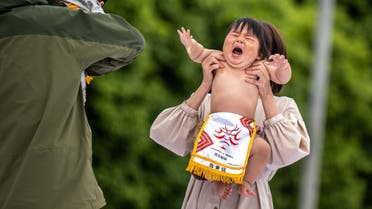 Children held by their parents start their Baby-cry Sumo match, resumed for the first time in four years due to the Covid-19 coronavirus pandemic, at the Sensoji temple in Tokyo on April 22, 2023. (Photo by Philip FONG / AFP)