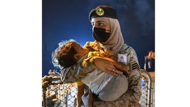 سعودی فوجی خاتون بچے کو اٹھائے ہوئے