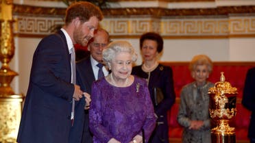 Britain's Prince Harry (L) and Queen Elizabeth look at the Webb Ellis Cup on a plinth during a Rugby World Cup reception at Buckingham Palace, London October 12, 2015. (Reuters)
