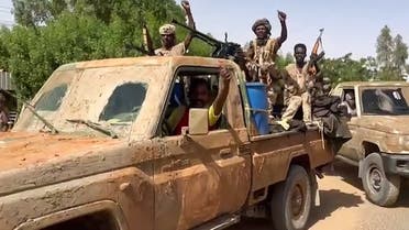 In this image grab taken from handout video footage released by the Sudanese paramilitary Rapid Support Forces (RSF) on April 23, 2023, fighters ride in the back of a technical vehicle (pickup truck mounted with a turret) in the East Nile district of greater Khartoum. (AFP)