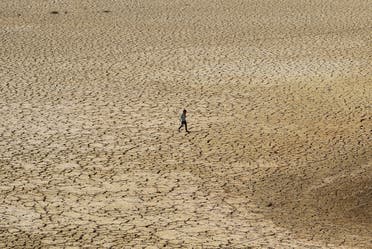 A boy walks on the cracked bed of the Chiba dam in the Nabeul Governorate, as the country battles with a drought, Nabeul, Tunisia April 1, 2023. (Reuters)