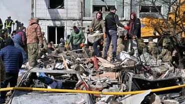 Rescuers and residents search for survivors in the rubble next to a damaged residential building in Uman, around 215km south of Kyiv, on April 28, 2023, after Russian missile strikes targeted several Ukrainian cities overnight. (AFP)