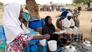 Fatma Dahab Ousman, a Sudanese refugee who fled the violence in her country, sells tea and porridge to other refugees near the border between Sudan and Chad, in Koufroun, Chad, on May 1, 2023. (Reuters)