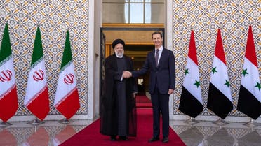 This handout picture released by the Iranian Presidency shows, Syria’s President Bashar al-Assad (R) receiving his Iranian counterpart Ebrahim Raisi (L) at the presidential palace in Damascus on May 3, 2023. (AFP)