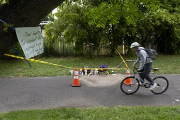 Un cycliste passe devant un mémorial de fleurs, le lundi 1er mai 2023, marquant l'endroit où Karim Abou Najm, diplômé de l'UC Davis, a été mortellement poignardé à Sycamore Park à Davis, en Californie.  (The Associated Press)